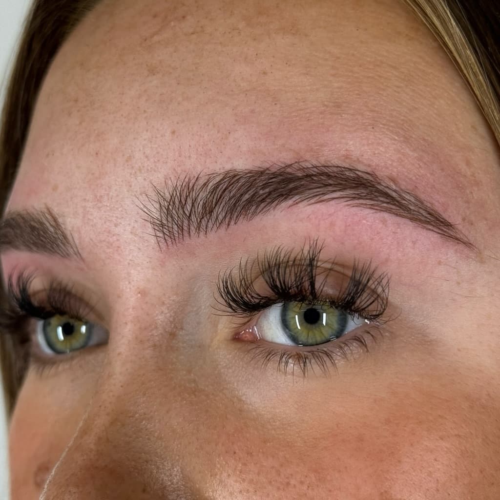 Close-up of professionally microbladed eyebrows with natural hair strokes
